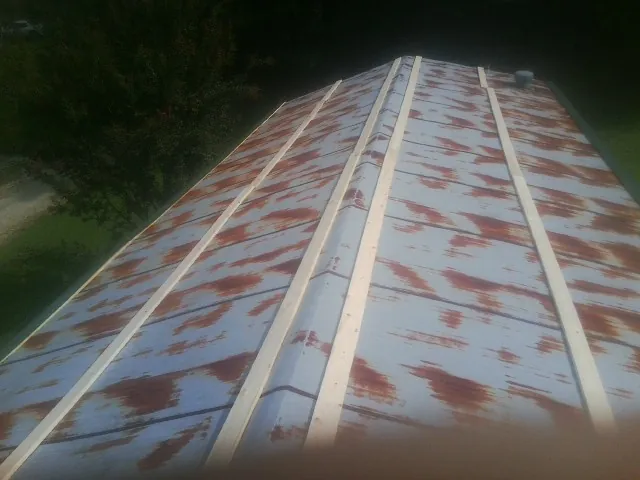 Rusted metal roof panels with new wood purlins before replacement — Storm Damage Roof Repair in South Byron by Roofing Brothers