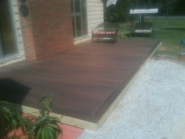Freshly stained wood deck built against a brick home in South Byron