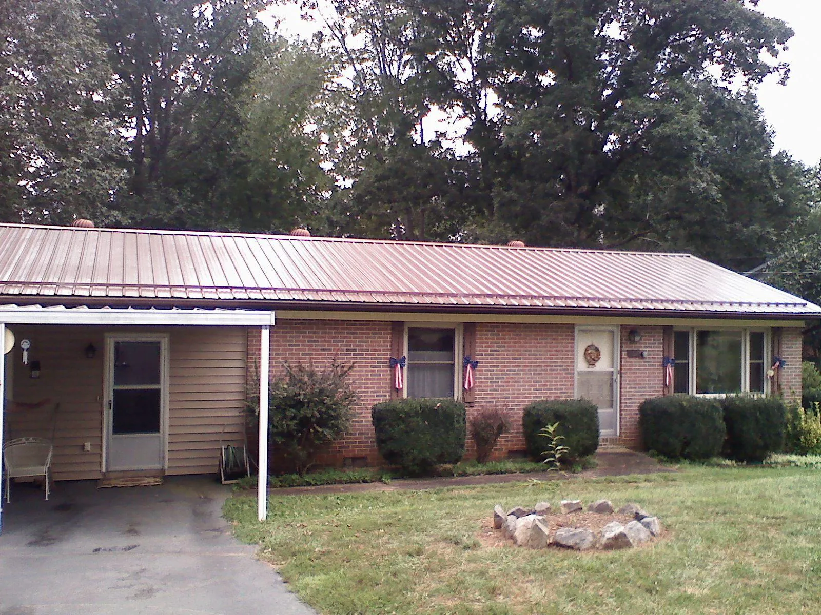 Bronze metal roof and carport on a brick ranch home — Roof Repair work by our crew in South Byron
